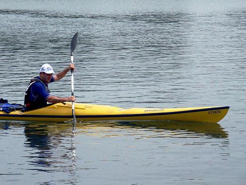 Photo of a person rowing in a yellow kayak